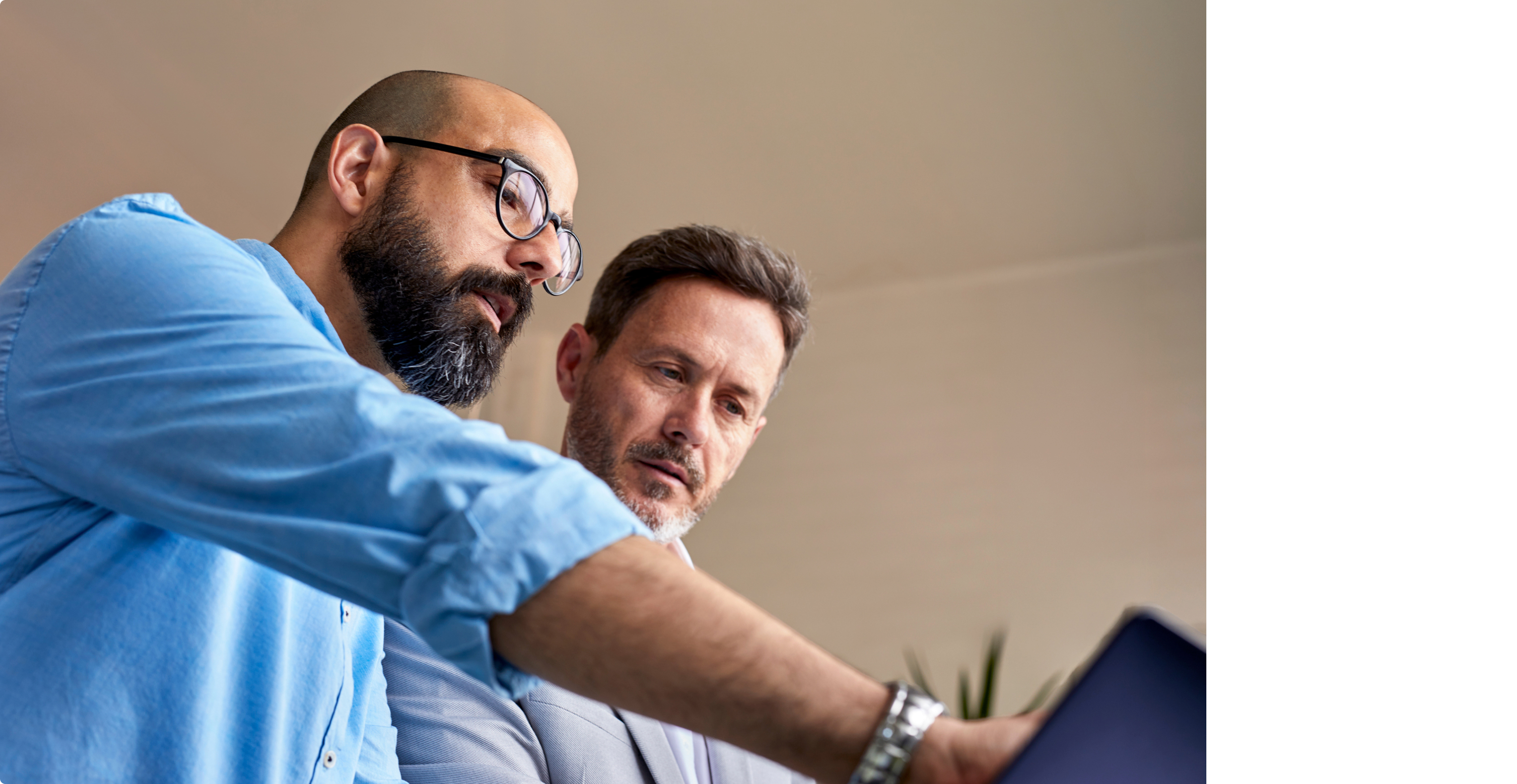 Two male security professionals reviewing data on a tablet together